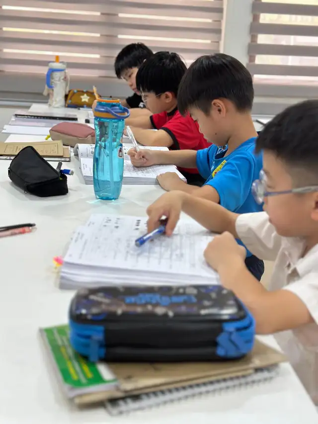几个男生并排坐着写练习